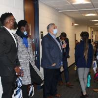 People in suits listening to presenter in hallway